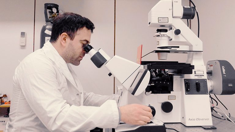 Alejandro Peñalva trabaja en el microscopio.